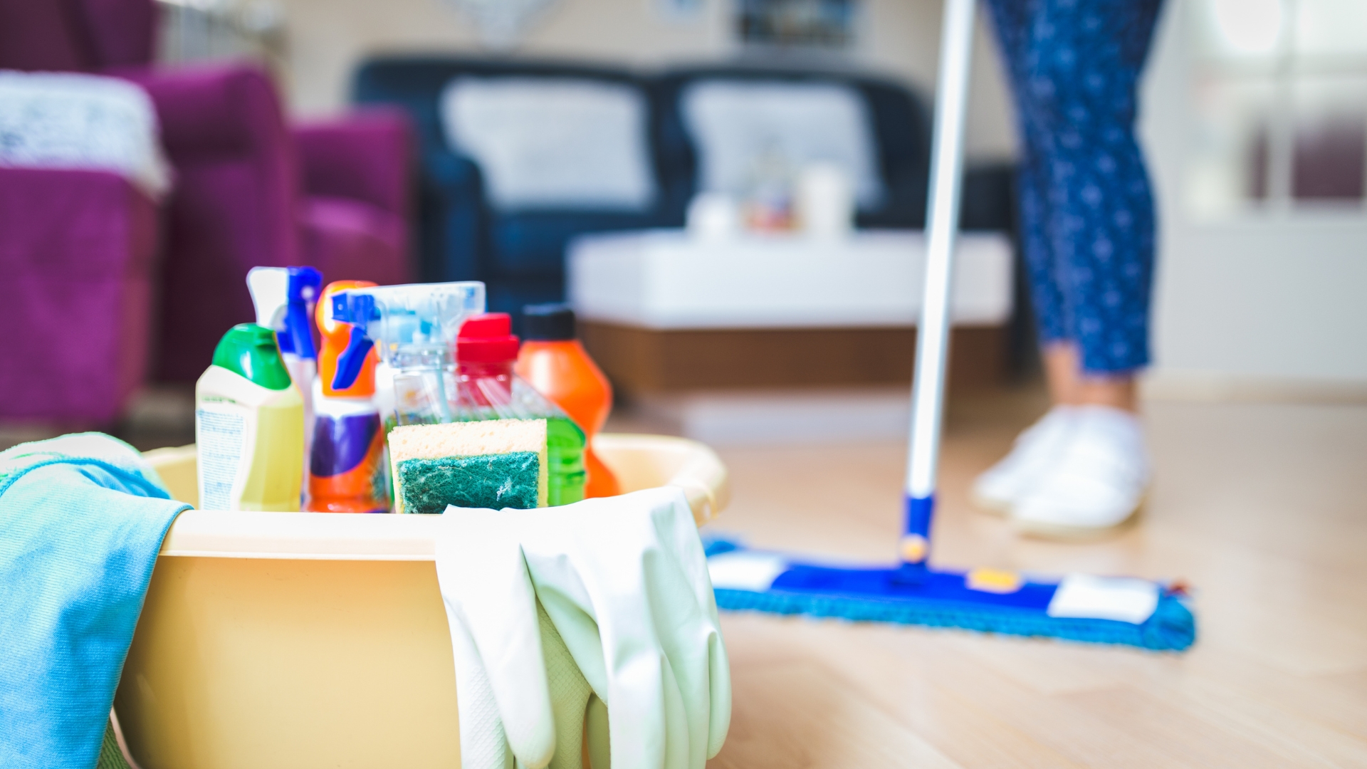 A person cleaning a wooden floor with a mop